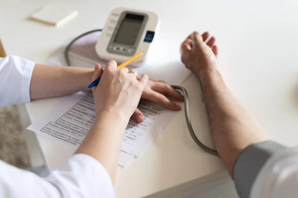 Ly sữa hạt bên cạnh một đĩa hạt óc chó và hạnh nhân