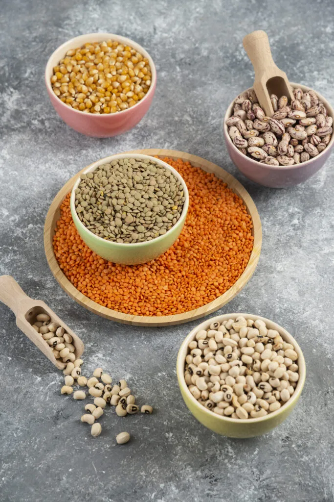 colorful bowls various uncooked beans lentils corns marble table surface 1