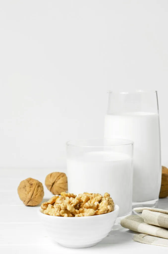 milk from walnuts nuts white wooden background products containing vegetable protein vitamins useful amino acids healthy vegetarian diet copy space