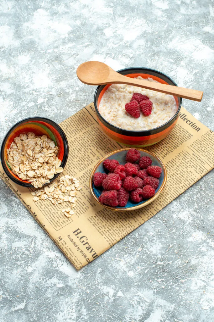 front view tasty porridge with raspberries light table