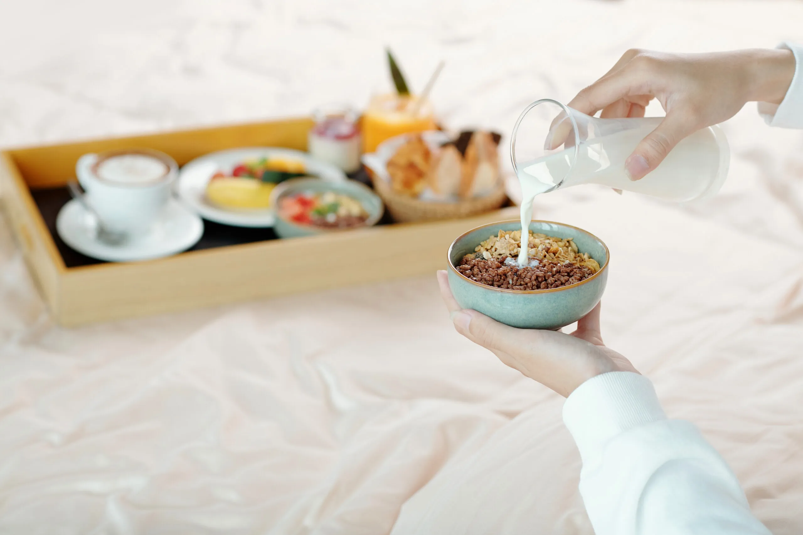 hands young woman adding milk bowl granola when sitting bed with breakfast tray scaled