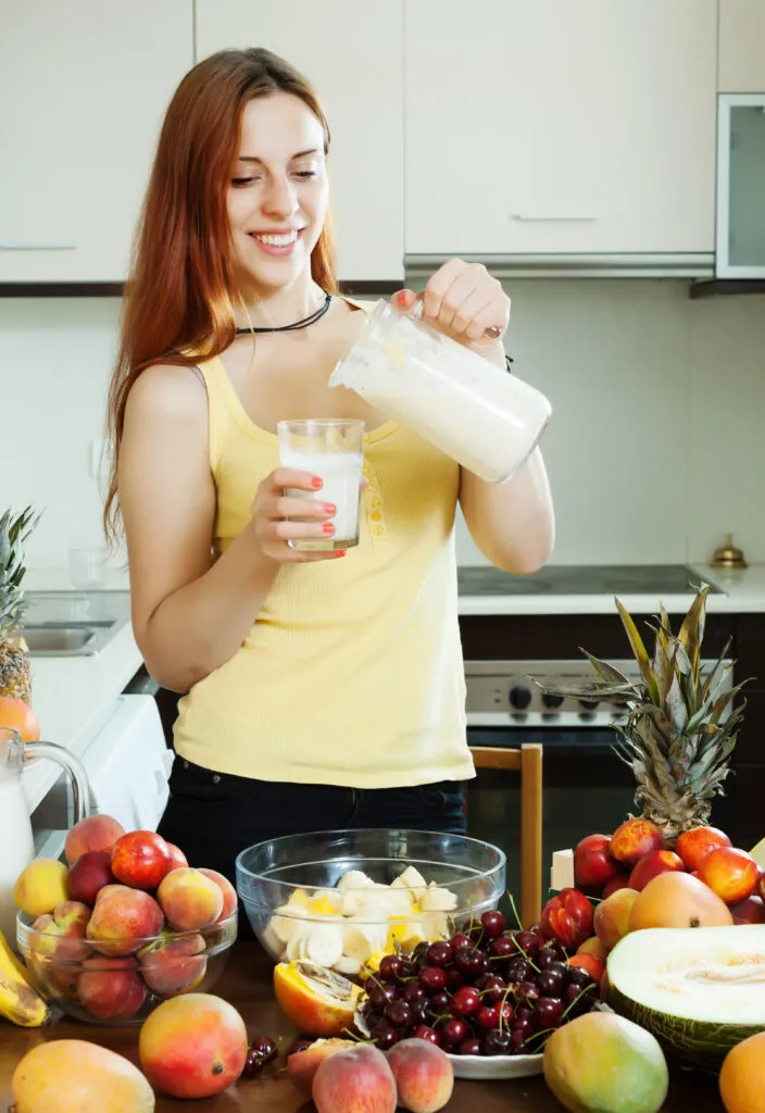 happy woman drinking milk cocktail with fruits 1
