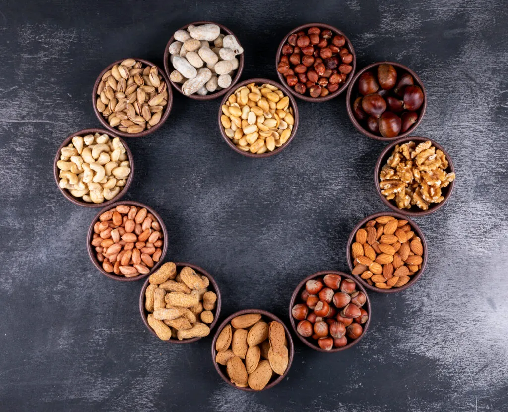 assorted nuts dried fruits heart shaped mini different bowls with pecan pistachios almond peanut top view