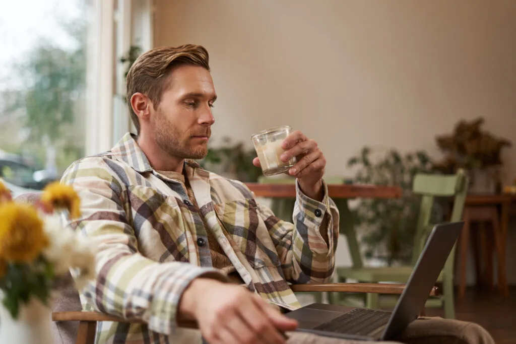 portrait young freelancer man casual clothes sitting cafe drinking coffee working