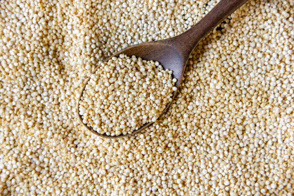 top view quinoa with wooden spoon