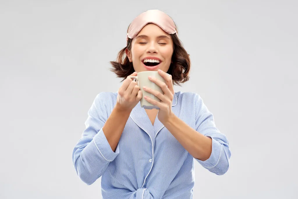 woman pajama sleeping mask drinking coffee