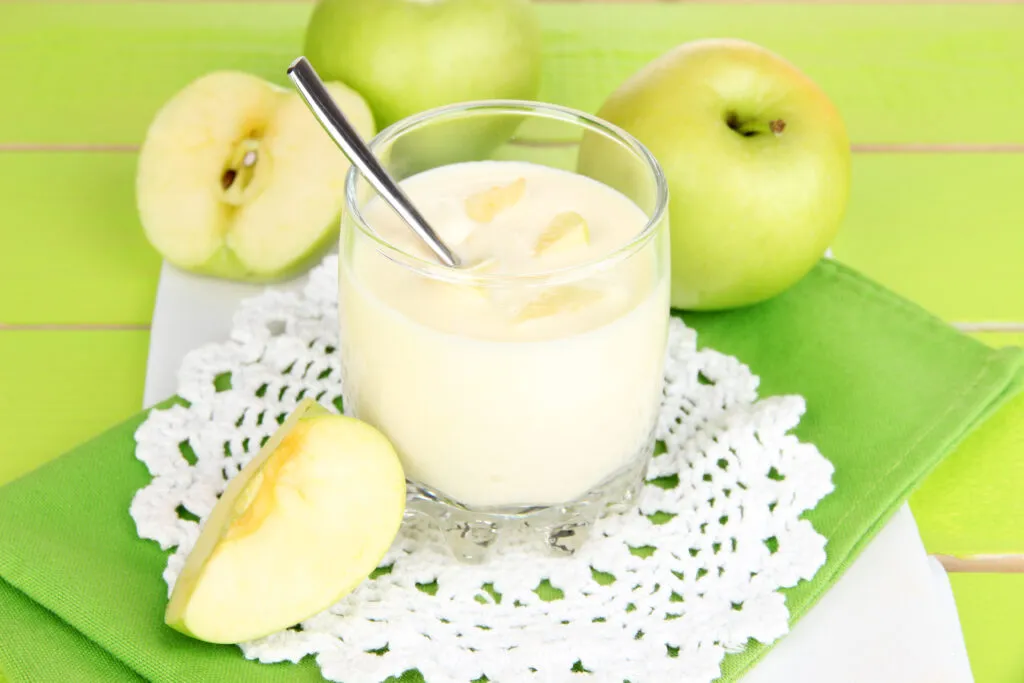delicious yogurt glass with apple blue tablecloth
