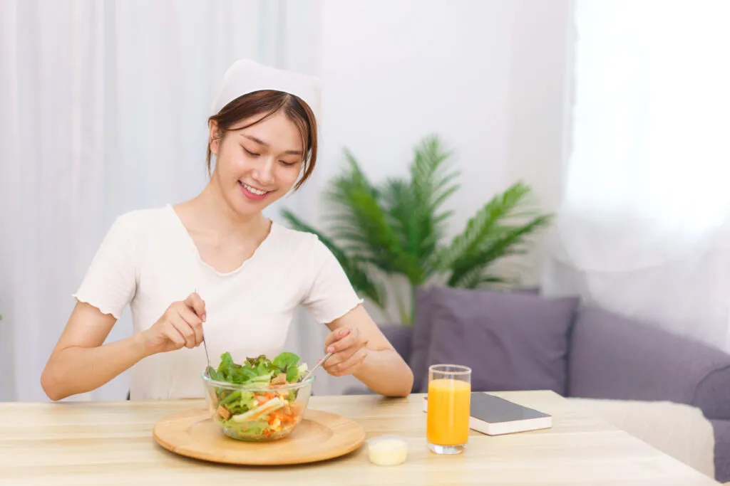 lifestyle living room concept young asian woman mixing vegetable salad bowl breakfast