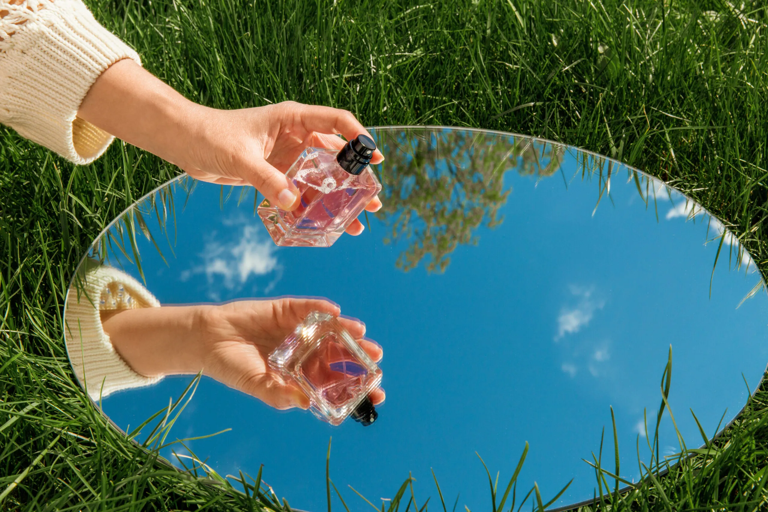 hand with perfume sky reflection mirror scaled
